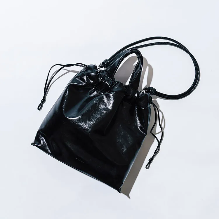 すべてを包み込む、頼れる黒。
カジュアルな装いも、一気に仕事モードに切り替えてくれる黒のバッグ。シンプルながら艶やかな質感が着こなしのアクセントに。ハンドルと程よい長さのストラップを備えた2WAY仕様。荷物を無造作に放り込める巾着型で、安定した底マチのあるデザインは日々駆け抜ける私たちの強い味方に。